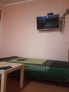 ラメンスコエにあるV Gostyakh U Skazkiのベッド1台と壁掛けテレビが備わる客室です。