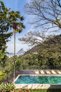 a pool with a palm tree and a view of the ocean at Chez Georges in Rio de Janeiro