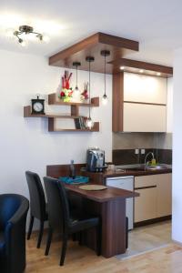 uma cozinha com mesa e cadeiras e um balcão em DM apartment em Niš
