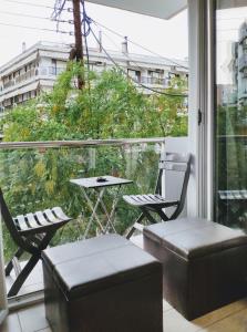 a balcony with two chairs and a table and a window at Standard Apartment by Prima Lodging in Thessaloniki