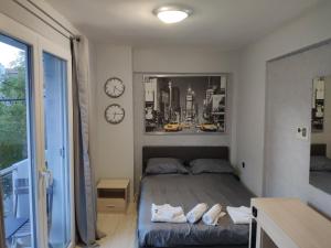 ein Schlafzimmer mit einem Bett und zwei Uhren an der Wand in der Unterkunft Standard Apartment by Prima Lodging in Thessaloniki