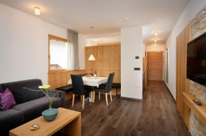 een woonkamer met een bank en een tafel bij Appartement-Hotel Beatenhof in Tirolo