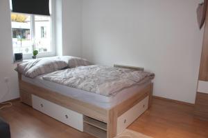 a bed sitting in a room with a window at Apartment Na skali in Kranj