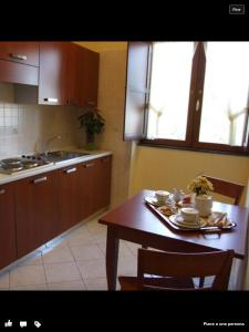 a kitchen with a wooden table and a table and chairs at Monte Degli Ulivi Country House in Mercato San Severino