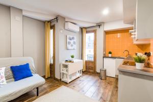 a living room with a couch and a kitchen at La Arbolada in Navacerrada