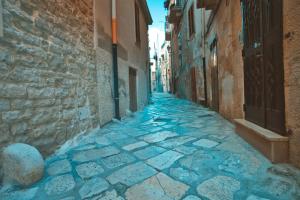 an alley in an old town with blue stones at Il Vicolo - Affittacamere in Ruvo di Puglia