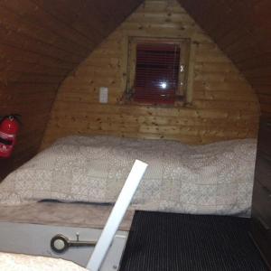 a bed in a log cabin with a window at Das kleine Ferienhaus in Berlin +14 photos