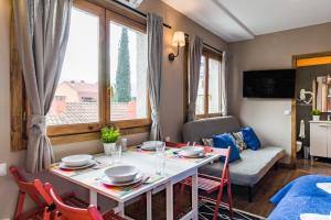 a dining room with a table and chairs and a couch at La Arbolada in Navacerrada