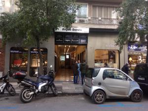 une moto et une petite voiture garées devant un magasin dans l'établissement TONI'S Studio Syntagma, 1 min from Metro station, à Athènes