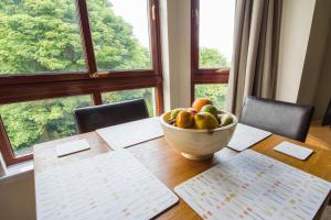a bowl of fruit sitting on a table in front of a window at South Groathill - Lovely 2 bed with Castle View in Edinburgh