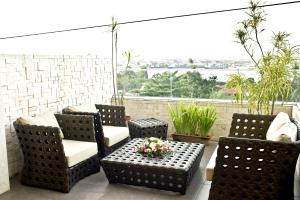 a patio with chairs and a table with flowers on it at Goldberry Suites and Hotel - Mactan in Mactan