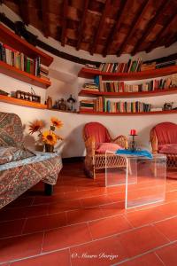 FaugliaにあるMulino a ventoのリビングルーム(椅子2脚、テーブル、本付)