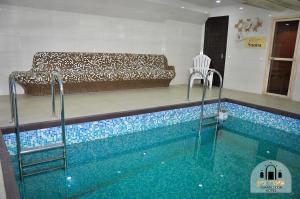 a swimming pool with a couch in a living room at Shaarei Zion in Uman