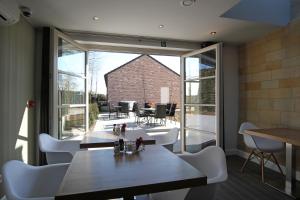 a restaurant with white chairs and tables and a large window at B&B 4 Seasons in Riemst