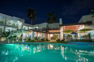 Una piscina frente a un edificio por la noche. en Hotel Palace Inn, en Tuxtla Gutiérrez