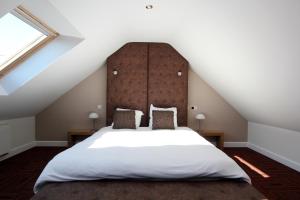 een slaapkamer met een groot wit bed op een zolder bij B&B 4 Seasons in Riemst