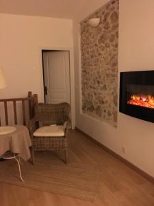 a living room with a fireplace and a chair at Vieille Ville 2 - La Petite Maison à Safranier, 2 bedrooms, max 4 adults and 2 kids in Antibes