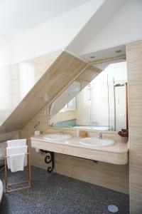 Un baño con dos lavabos y un espejo grande. en Villa Soledad, en Torrejón de Ardoz