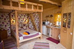 a bedroom with a bunk bed and a kitchen at Tõnise Holiday Houses in Lilbi