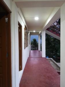 a corridor of a house with a red carpeted hallway at Delight Homestay in Cherrapunji