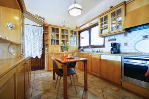 a kitchen with wooden cabinets and a small wooden table at Villa Katerina-Despina in Argoulidhés