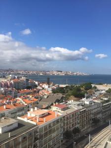 a view of a city with the ocean and buildings at Over the Rainbow in Almada