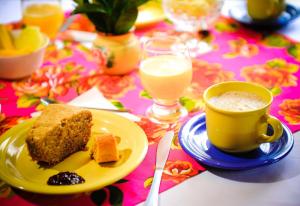 um prato de bolo e uma chávena de café numa mesa em Encantos do Vale Pousada e SPA Cultural em Bueno Brandão