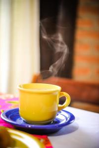 Encantos do Vale Pousada e SPA Cultural في بوينو برانداو: فنجان قهوة أصفر على طاولة مع دخان
