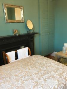 a bedroom with a bed and a mirror and a fireplace at The Townhouse B and B in Aylesbury