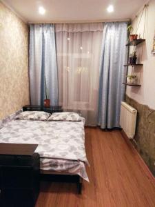 een slaapkamer met een bed en een raam met blauwe gordijnen bij Guest House Pid Dubom in Lviv