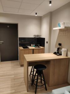 a kitchen with a wooden table and a stool at H33 Apartamenty in Bytom