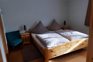 KottenbornにあるB&B Kottenbornのベッドルーム(木製ベッド1台、青い椅子付)