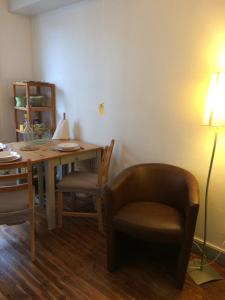 a living room with a table and a chair and a lamp at Appartement 4 personnes centre ville in Châteauneuf-sur-Loire