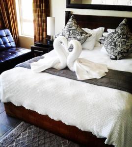 una cama con dos cisnes hechos de toallas en Rostalyn Guesthouse, en Durban