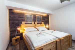 een slaapkamer met een groot bed met een houten hoofdeinde bij Kopec 67 in Štramberk