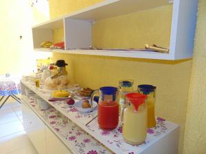 a kitchen counter with some drinks on a shelf at Pousada Sabrinna in Maceió
