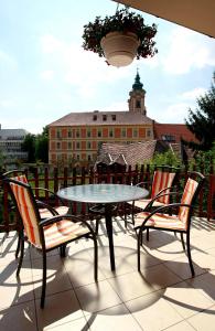 una mesa y sillas en un patio con un edificio en Dobó Vendégház, en Eger