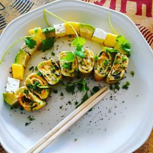 un plato de comida con sushi en un plato con palillos chinos en Rostalyn Guesthouse en Durban