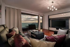 salon z kanapą i telewizorem z płaskim ekranem w obiekcie VILLA PARADISE - Modern and Sophisticated w Funchal