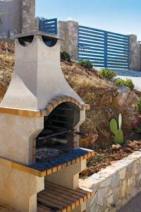 a outdoor pizza oven with a face on it at Belchior Nunes in Almargens