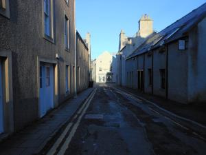 an empty street in an alley between buildings at Orkneyinga in Kirkwall