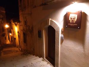 eine Gasse mit einem Schädelschild an der Seite eines Gebäudes in der Unterkunft Lucernaio Rooms in Ragusa