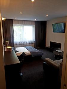 ein Hotelzimmer mit einem Bett und einem Fenster in der Unterkunft Azymut Hotel & Restaurant in Andrespol