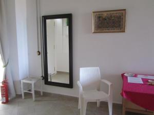 a mirror in a room with two chairs and a table at Villa Amalia Suites Malaga in Málaga