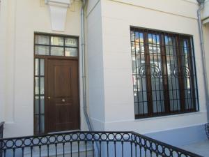 a building with a wooden door and two windows at Villa Amalia Suites Malaga in Málaga