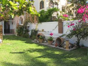 a garden with a bench and flowers in a yard at Villa Amalia Suites Malaga in Málaga