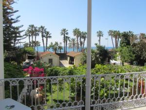 a balcony with a view of the ocean and palm trees at Villa Amalia Suites Malaga in Málaga