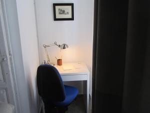 a desk with a blue chair and a lamp on it at Villa Amalia Suites Malaga in Málaga
