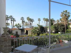 a balcony with a white table and palm trees at Villa Amalia Suites Malaga in Málaga