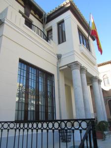 a building with a flag in front of it at Villa Amalia Suites Malaga in Málaga